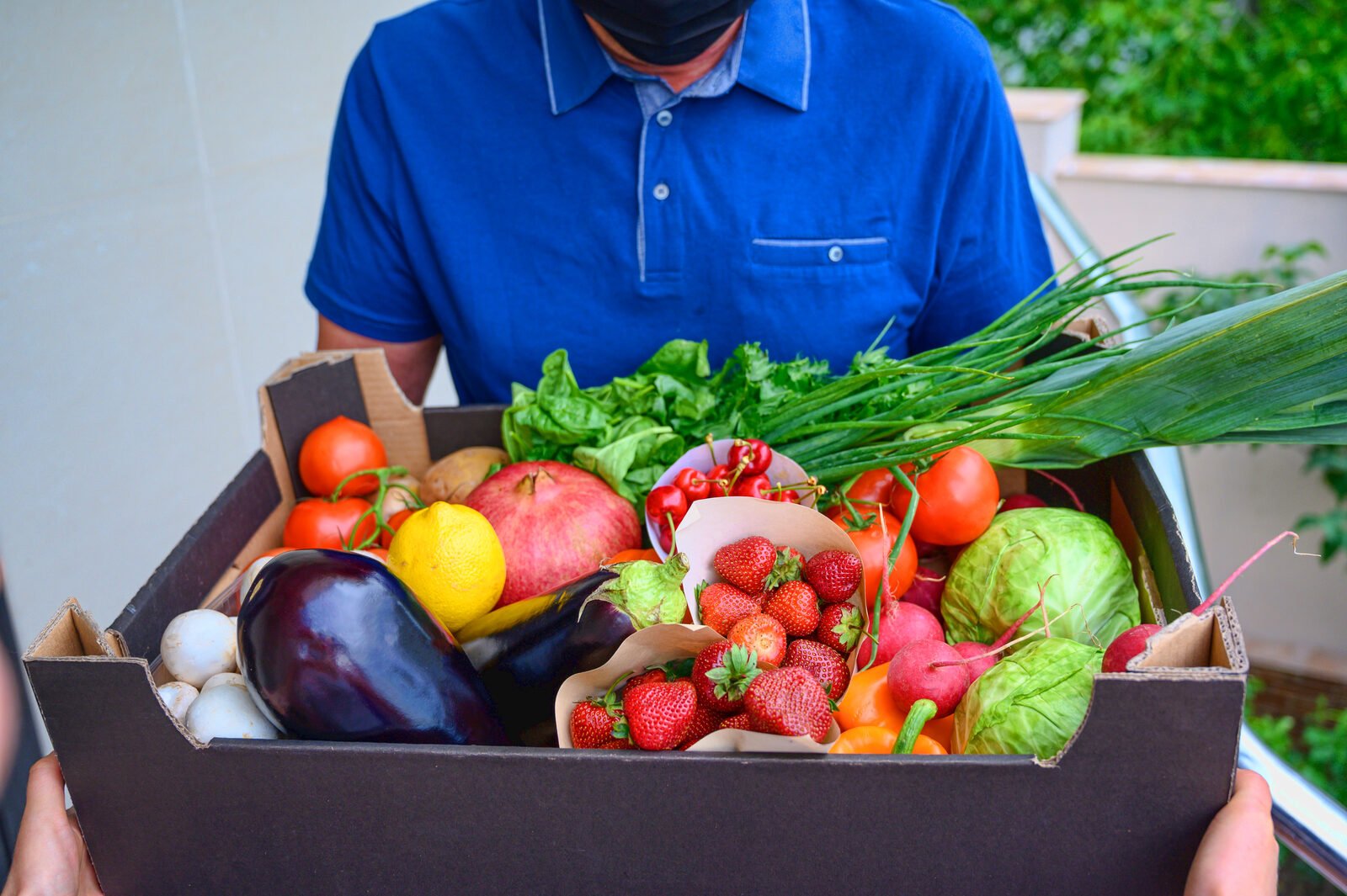 Courier delivering a chilled vegetable box to the door