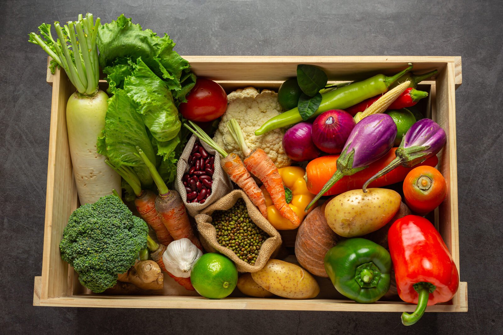 A wooden crate of whole organic vegetables